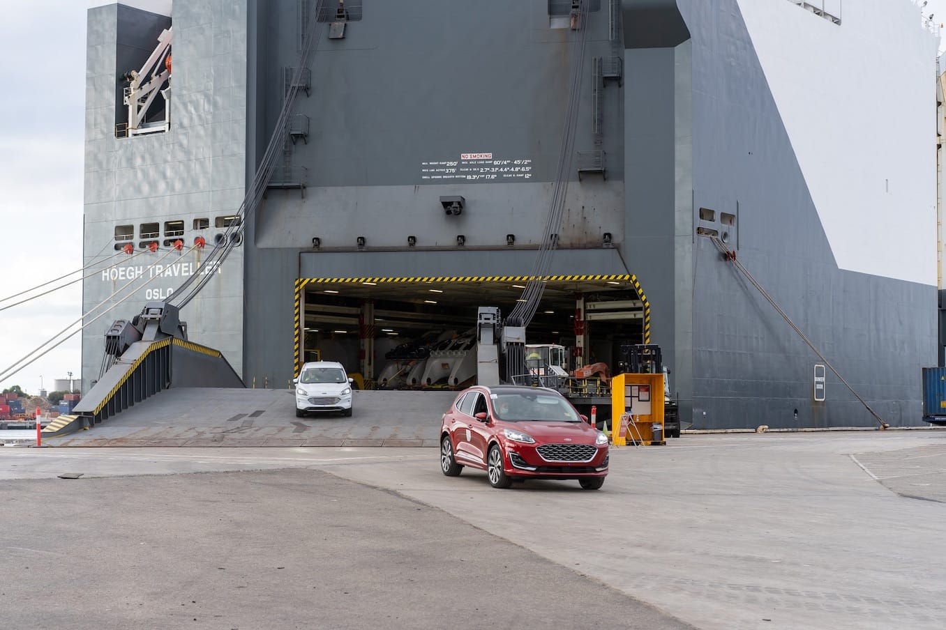 Cars driving off a ship at a dock